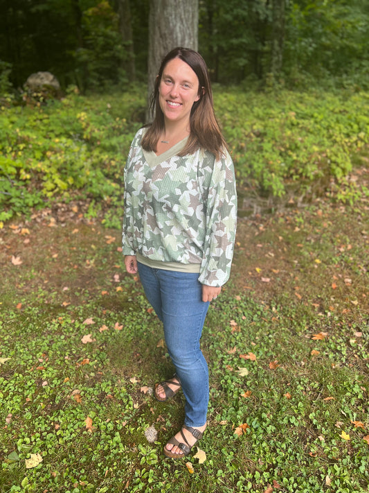 Mid-size women in her thirties modeling a green star camo-like waffle long sleeve shirt