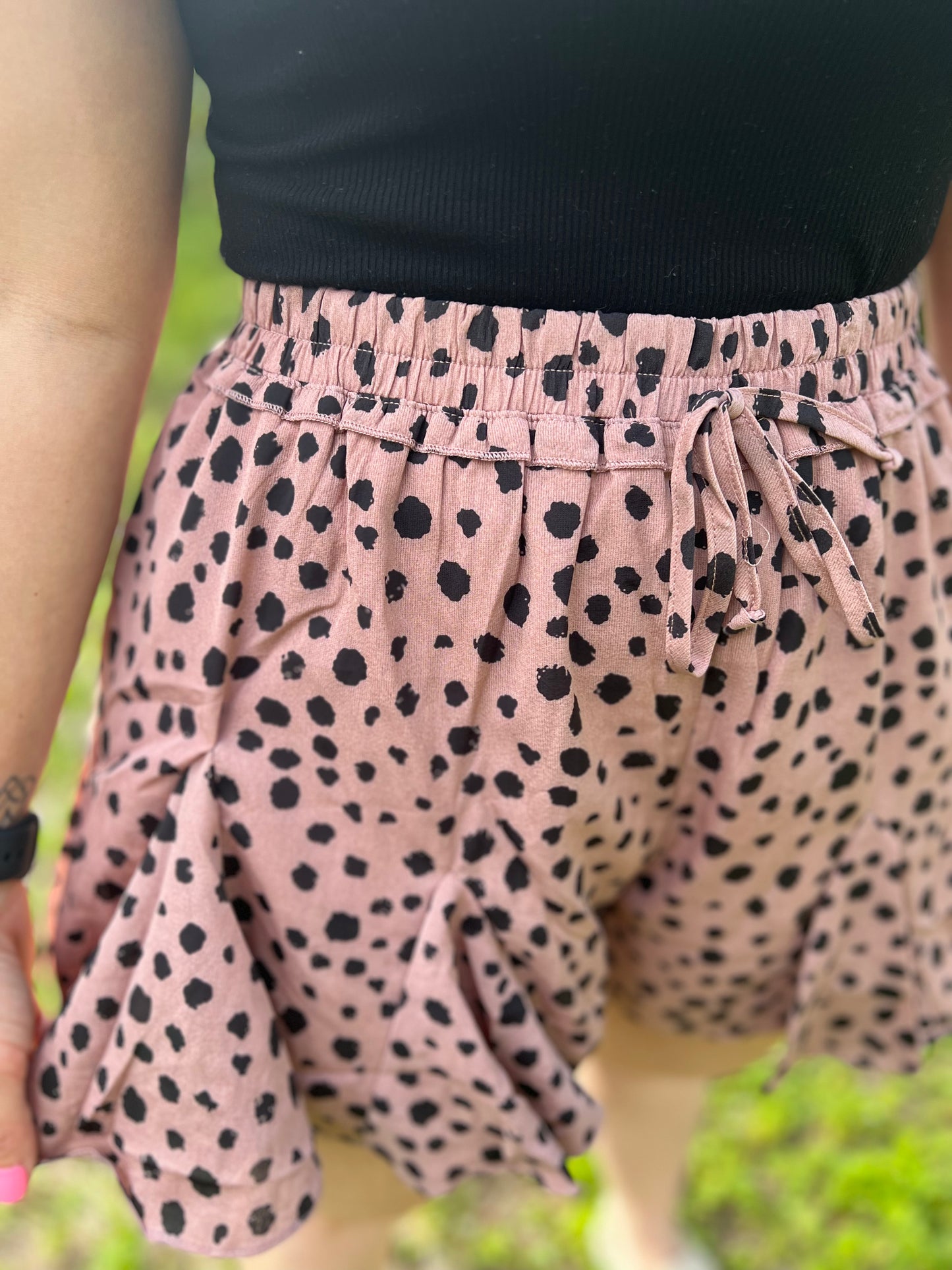 Black polka dot on tan flared shorts, almost leopard print. 