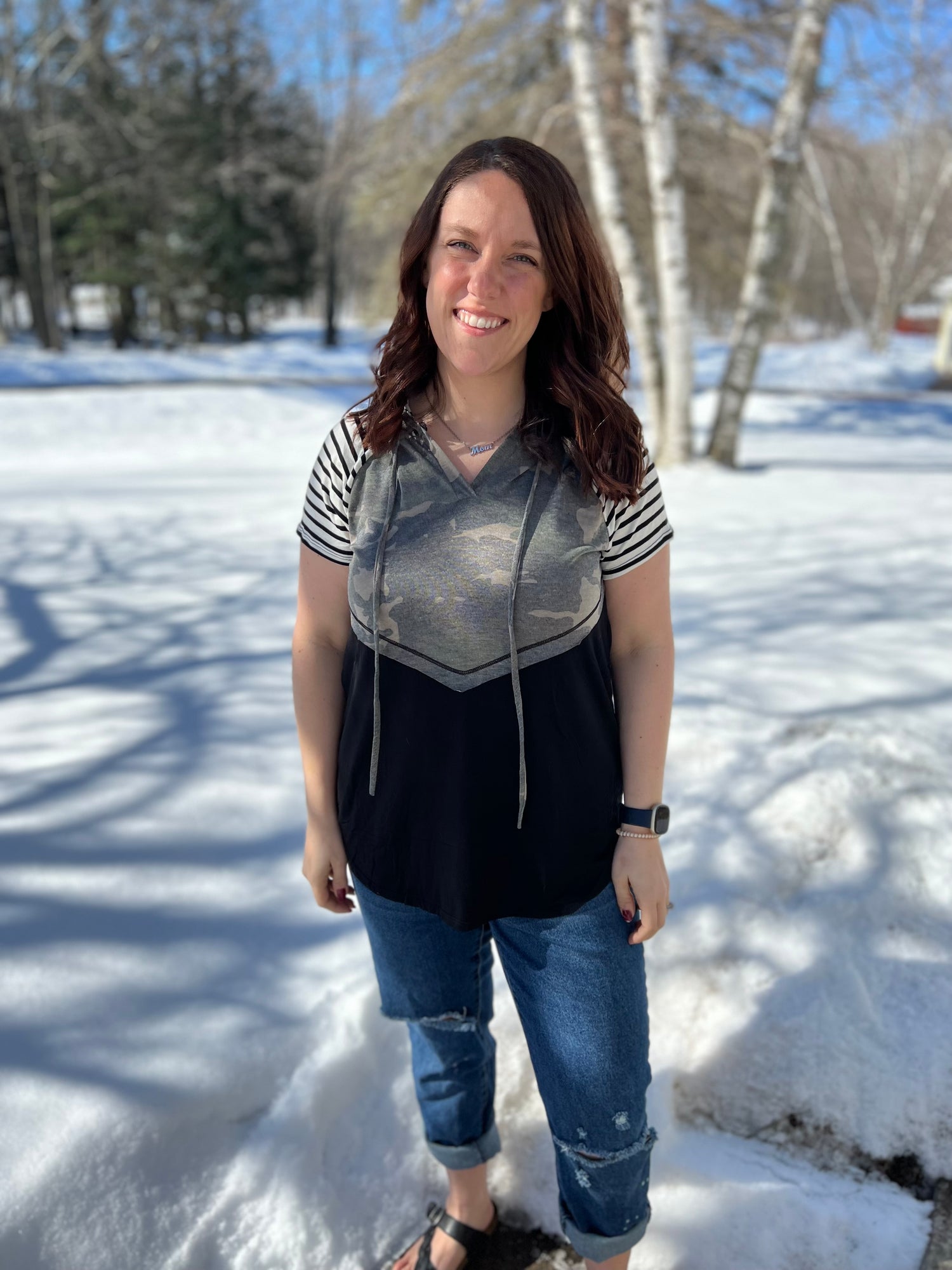 A women wearing a camo print solid and stripe mixed t-shirt. 