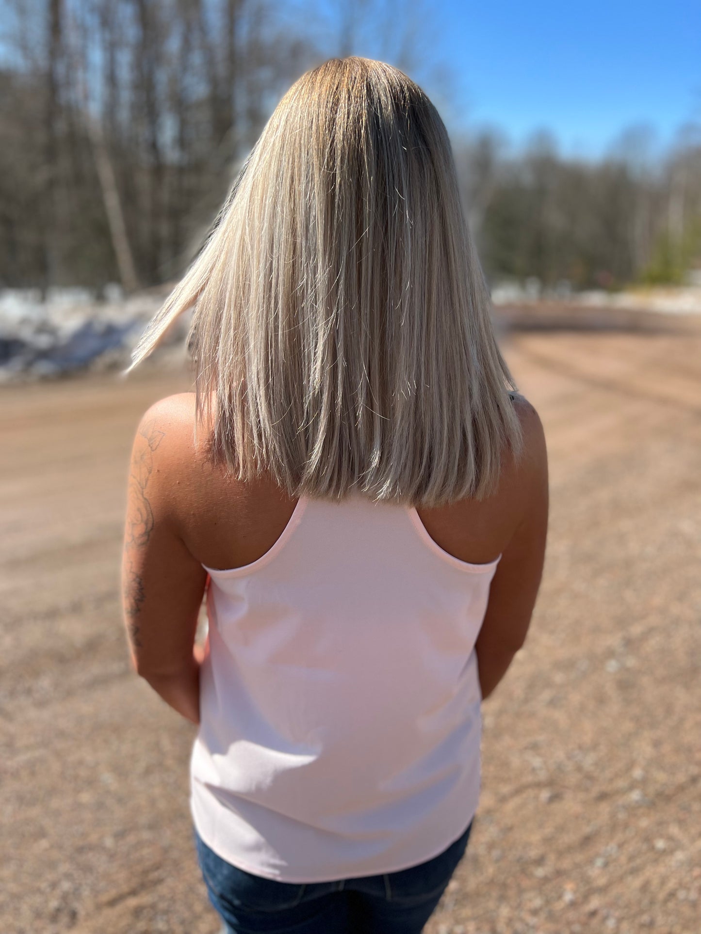 A woman wearing a blush pink tank top. 