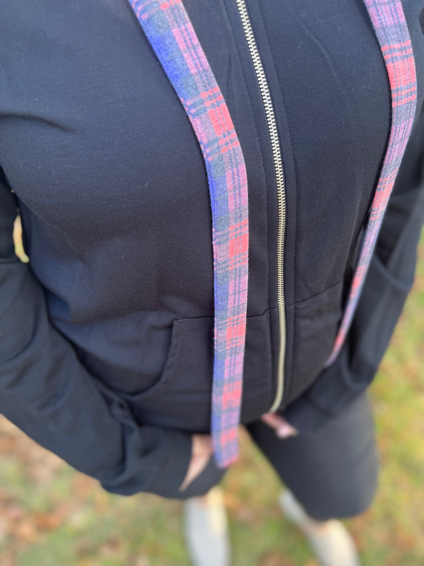 Black zip-up hoodie with plaid in hood and hoodie strings