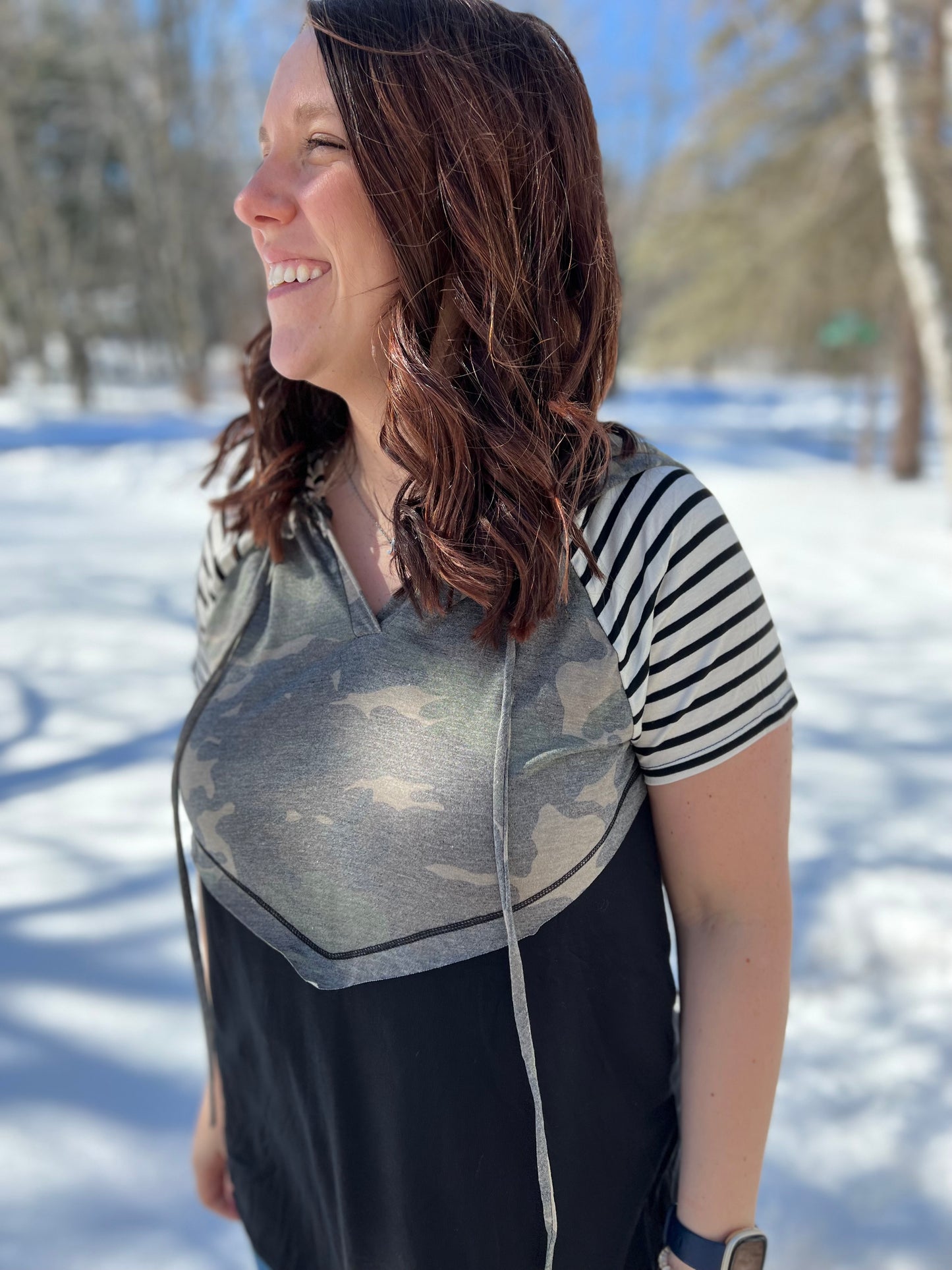 A women wearing a camo print solid and stripe mixed t-shirt. 